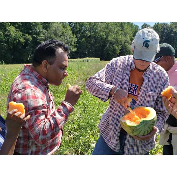 Taking a watermelon break during a field visit.