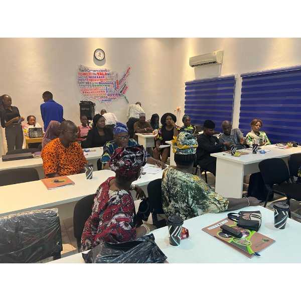 Attendees at a RSM2SNF event, a classroom with white tables where a group of people are sitting with RSM2SNF folders in front of them.