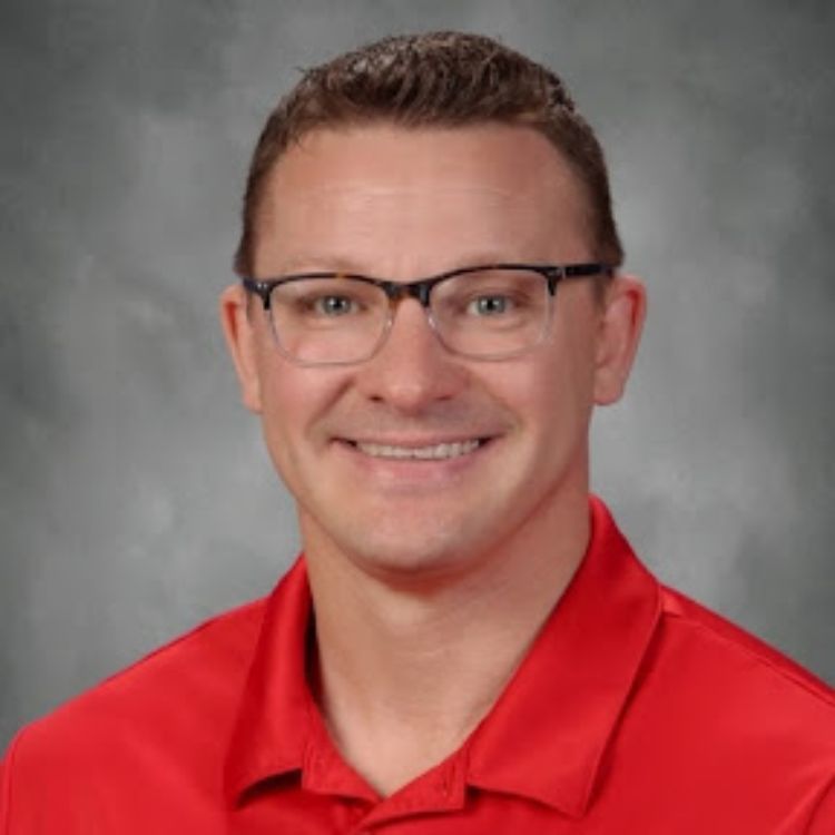 A white male with dark hair and glasses wearing a red shirt.