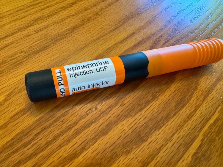 A photo of an epinephrine injector sitting on a table.