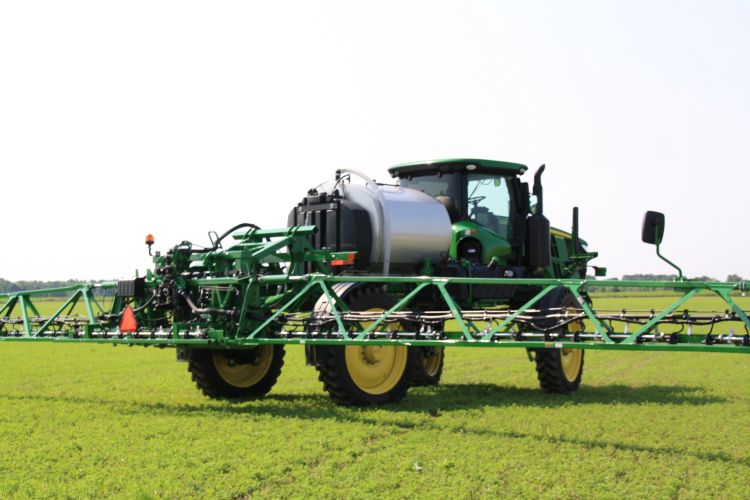 A John Deere sprayer in a field.