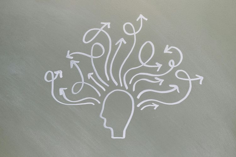 A drawing of a cartoon head in profile without any details or features. The head has a bunch of swirling arrows coming out of it going in different directions.