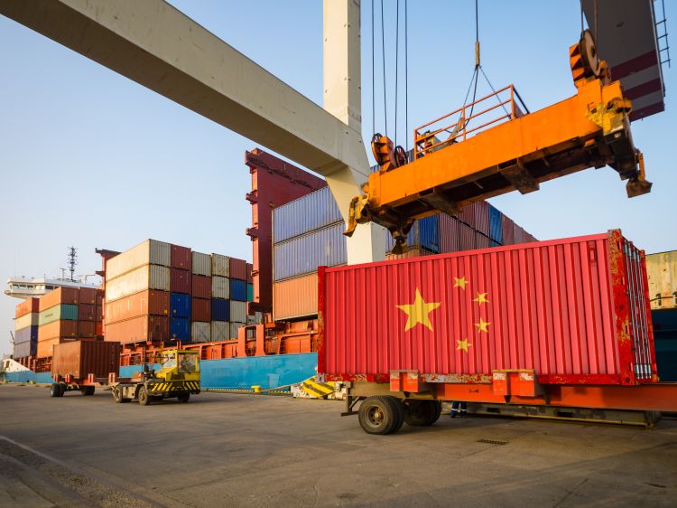 Cargo containers in a shipping yard. One container is painted as a flag of the People's Republic of China.