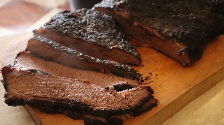 Cooked and cut red meat on a cutting board.